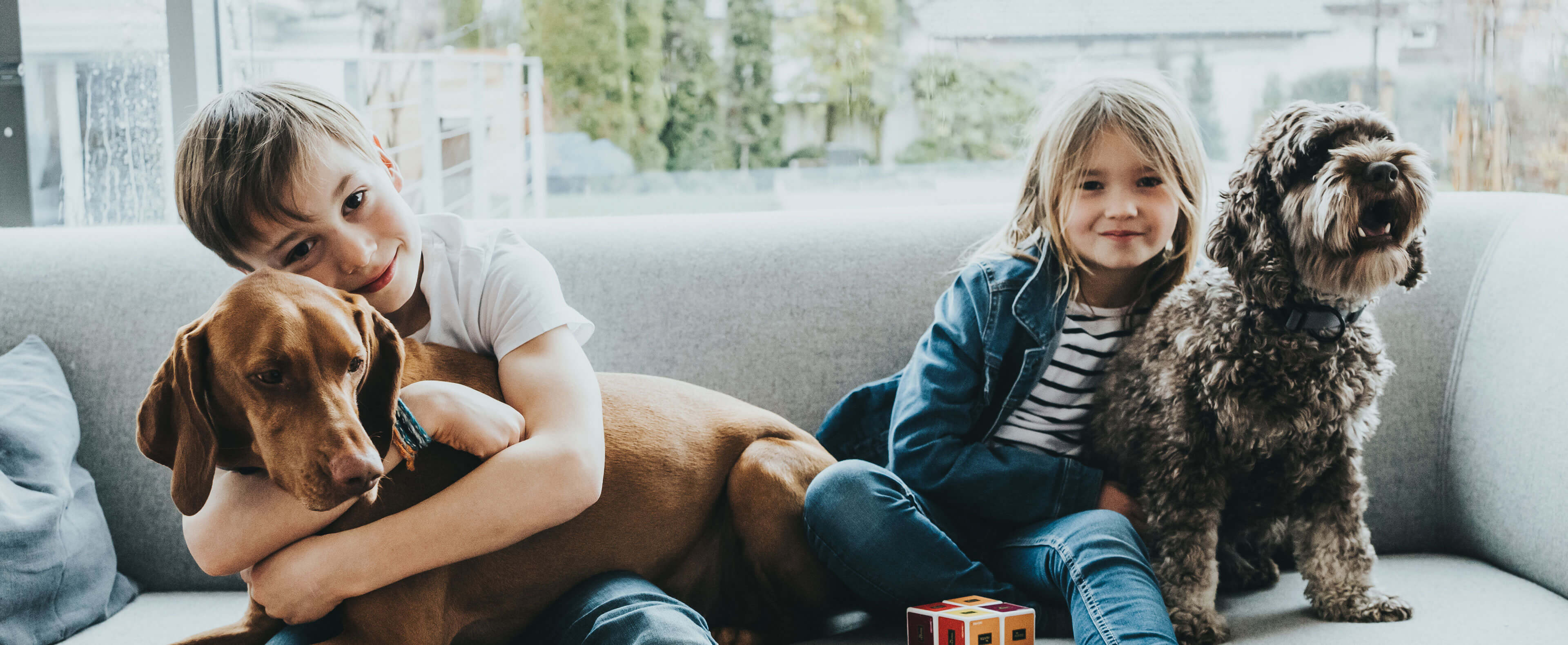 two kids sitting with two dogs