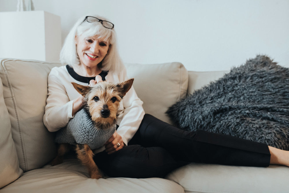 woman on couch petting dog